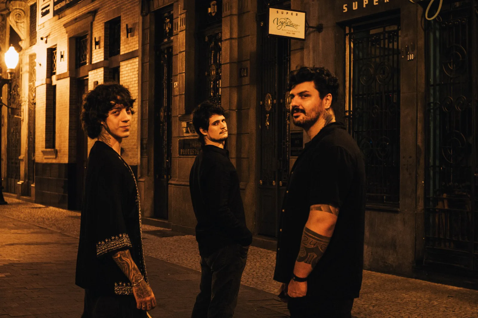 Os três integrantes da Curse Cult em uma rua de Santos à noite