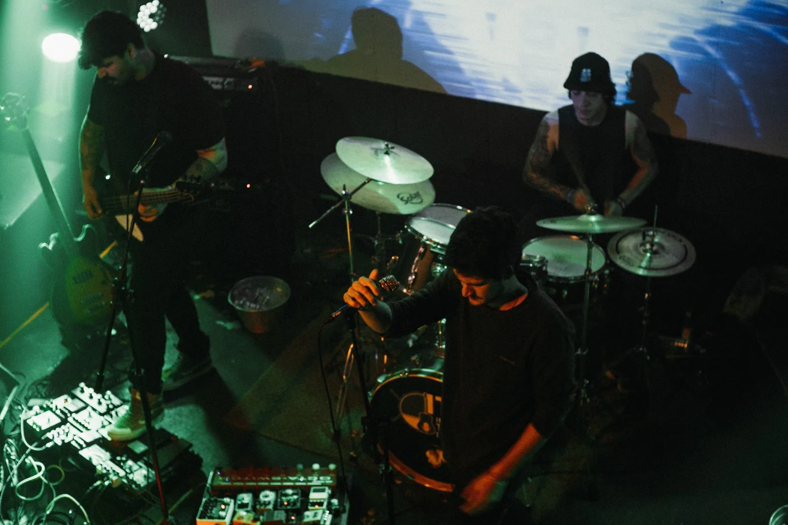 Curse Cult tocando ao vivo sob luz verde, vista do mezanino